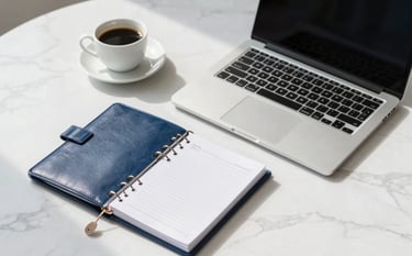 High-angle shot of a minimalist workspace in the US. A high-end laptop, a cup of coffee, and a leather-bound financial planner are arranged on a white marble desk. Soft sunlight illuminates the scene, emphasizing precision. Palette features snow white and corporate blue.