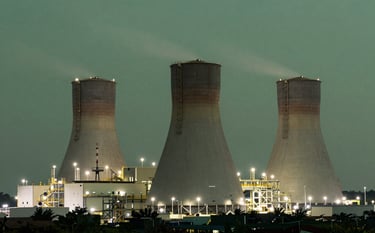 A high-tech waste-to-energy conversion plant located in a Southeast Asian / Indonesian industrial park during twilight. The facility is illuminated with soft mist white lights against a deep sage green sky, showcasing a modern and sustainable energy solution.