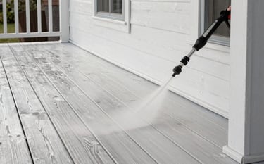 A beautiful wooden porch in a North American / US home setting, looking pristine and clean. The wood texture is rich with soft pearl white light reflecting off the surface. A professional pressure washing wand is visible in the corner, with muted slate gray accents in the shadows.
