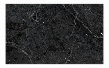 A high-end dark granite slab with rich, deep textures and crystalline reflections. Professional lighting highlights the precision craftsmanship and the depth of the natural stone. Colors emphasize #0D0D0D and subtle #A18A6A highlights for an exclusive brand mood.