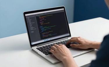 An IT professional using a modern laptop in a clean mist white workspace. On the screen, code and network diagnostic tools are visible. In the background, soft sky blue and deep midnight blue accents complement the professional setting. The focus is on trust and technical expertise.