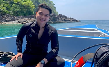 a man in a wetsuit sitting on a boat