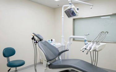 A bright, modern dental examination room with advanced medical technology and ergonomic design. A clean, sterile environment in a high-end facility for Global / International Medical Tourism. Lighting is soft and professional, highlighting steel gray and premium teal accents in the equipment.