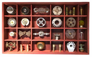Wood box with 24 metal objects placed in 24 niches.