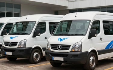 A fleet of professional white transport vehicles branded with subtle royal blue accents, parked in a modern corporate courtyard in Abidjan. West African / Ivorian setting, sophisticated atmosphere, in a clean, professional lighting.