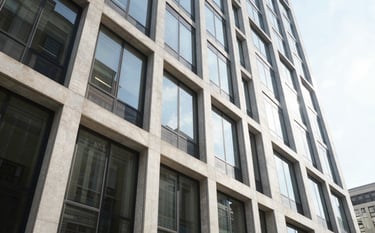 The modern exterior of a high-end financial institution in the United States, featuring large glass panels and clean architectural lines. The lighting is bright and airy, conveying success and stability.