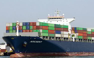 A massive container ship at a modern North American port, loaded with multicolored shipping containers including primary green and red accents, wide-angle photography, bright daylight, conveying global logistics efficiency.