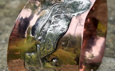 A wide copper cuff fused with reticulated silver