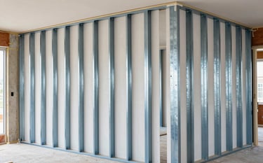 A high-end North American interior construction site with professional metal stud partitions and drylining boards perfectly installed. Bright, even lighting highlights the clean, technical precision of the build. Modern and reliable mood with Steel Blue and Off-white accents in the setting.