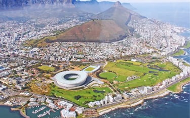 Aerial view of Cape Town Stadium and Table Mountain overlooking the South African coastline.