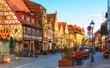 Charming cobblestone street in Nuremberg Germany featuring historic timber-framed houses and outdoor cafes.