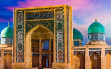 Barak-Khan Madrasah in Tashkent, Uzbekistan, featuring blue tiled domes and Islamic architecture at sunset.