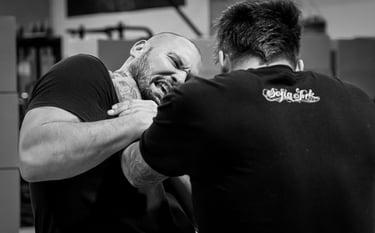 Two stuntmen grappling with one holding the other by the throat