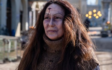 Portrait of an actress looking to the left  in zombie clothing and makeup on set