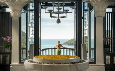 A lady overlooking a wellness resort bay from the lobby