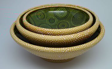Set of large nesting bowls with rolled rims, glazed on inside, dotted on outside