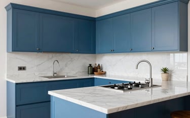A bright and modern kitchen in a Southern European / Spanish home. The cabinets are in steel blue and countertops are polished white marble. Professional lighting highlights the modern craftsmanship.