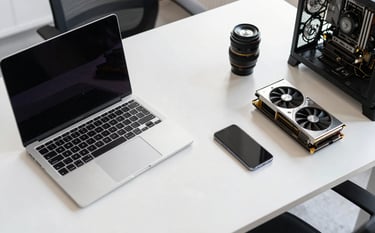 A top-down professional photograph of a clean, white workspace in a modern European / French office. A high-end laptop, a sleek smartphone, and high-quality computer components like a graphics card are neatly arranged on the desk. The lighting is bright and natural, reflecting a sense of precision and professional sales.