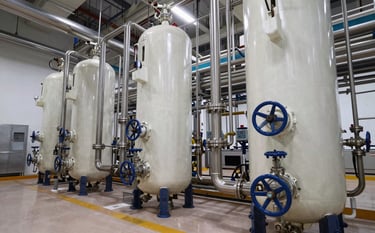 A wide-angle professional shot of an impeccably clean chemical processing plant. The composition shows stainless steel pipes and valves, with a color scheme of off-white and navy. Modern Hispanic / Industrial setting, focused on sterile and highly efficient technical infrastructure.