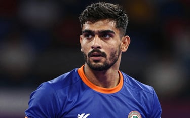 Close-up portrait of an elite Kabaddi player focused and intense, wearing a deep royal blue jersey with vibrant orange trim. Strong directional lighting, high contrast, reflecting the energetic and professional spirit of the federation.