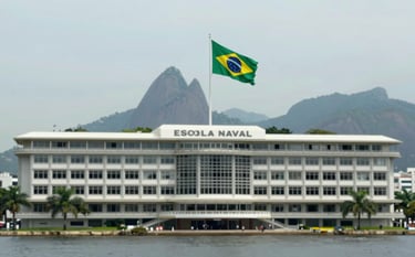 An authoritative wide shot of the Escola Naval building in Rio de Janeiro, with the Brazilian flag waving. The composition is clean and modern, evoking a sense of history and prestige. Palette includes #F8FBF8 and #1A1E1C.