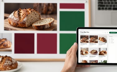 A top-down shot of a creative workspace with a mood board featuring artisanal bread photos, color swatches in Deep Ripe Crimson and Forest Green, and a tablet showing a social media grid. Professional, warm, and sophisticated atmosphere.