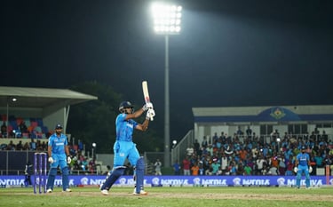 A dynamic photography shot of a modern cricket stadium in India during a night match, with intense floodlights and a blurred energetic crowd in the background, South Asian / Indian context, professional sports atmosphere.