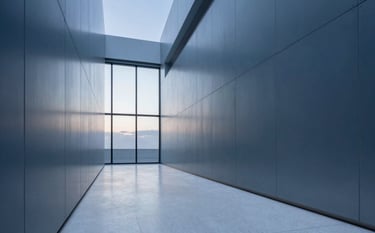 A wide-angle architectural photograph of a futuristic office corridor with walls made of brushed metal in muted steel blue. The floor is a polished mist white stone. In the distance, a large window reveals a soft slate grey sky at dawn. The lighting is diffused and professional, emphasizing security and reliability.