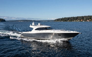 A high-end modern motorboat cruising smoothly on the Pacific Northwest waters near Friday Harbor. The scene is captured in clear daylight with North American / US coastal scenery in the distance. The deep navy of the water and steel blue of the sky reflect a professional and serene mood.