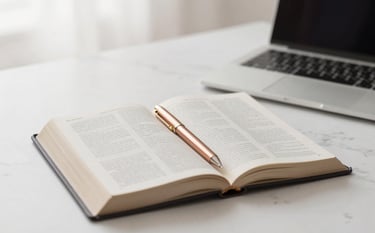A minimalist, elegant desk scene with an open Bible, a high-end rose gold pen, and a sleek laptop on a white marble surface. The lighting is soft and heavenly, featuring a gentle glow. Palette includes soft white and Rose Gold #C7A196.