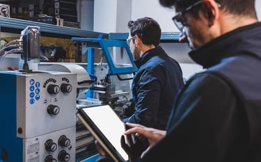 Pracownicy fabryki produkują części metalowe używając maszyny cnc