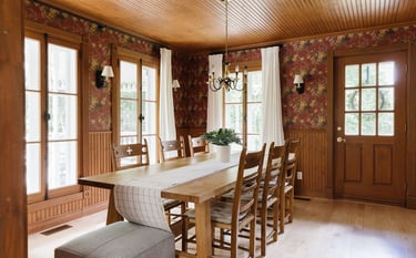 a dining room with a table and chairs, with a moody wallpaper