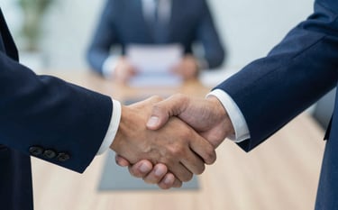 Close-up of a professional handshake between two people in business attire. The background is a blurred, sophisticated boardroom. The color palette features #3A506B and #E0E8F0, evoking trust and strategic partnership.