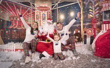 a family posing for a photo in front of a christmas tree