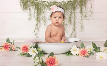 a baby in a bowl of flowers
