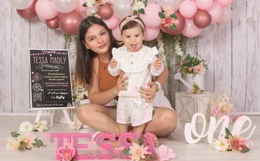 a man and woman with a baby in front of a cake