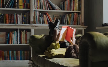 A girl reading on the sofa in her library