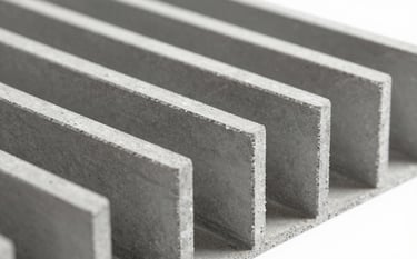 Clean, high-quality photograph of concrete U-shaped channels (canaletas) lined up in an orderly fashion. The shot emphasizes precision and structural integrity. The scene is bright and professional, utilizing soft shadows and the brand's metallic gray tones like #A9A9AE.