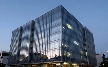 Modern architectural glass building in Guatemala City at twilight, representing corporate reliability and innovation. Sharp focus, deep blue and light gray lighting.