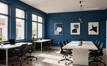 Sophisticated interior photography of a modern digital agency office in a Spanish / Iberian & Latin American location. Deep blue walls with minimalist art, large windows, and a clean, high-value ambiance. Soft shadows and a high-contrast composition featuring a warm white meeting area.
