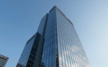 A low-angle shot of a modern glass skyscraper reflecting a clear blue sky, symbolizing corporate growth and stability. The style is clean and architectural. The color palette emphasizes #0A2A44 and #7BAED8 to evoke trust and authority.