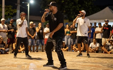 Action shot of a Brazilian rap battle at night in a public square, MCs with microphones, energetic crowd blurred in the background, warm gold lighting from street lamps.