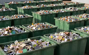 Photography of an organized Latin American industrial area featuring rows of forest green waste containers. The lighting is bright and professional, highlighting a sterile and efficient management of industrial residues. The scene is shot from a low angle to convey strength and scale.