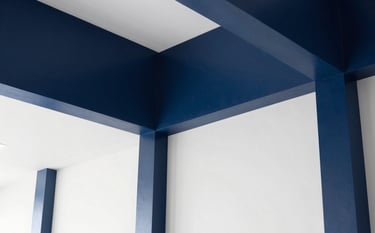 Clean, minimalist corporate interior architecture in a South American business setting. The scene features a high-contrast environment with navy blue architectural details and bright white walls, symbolizing stability and professional precision.