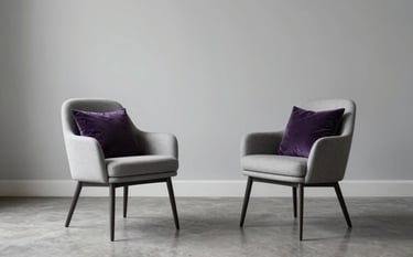 Two elegant modern chairs angled toward each other in a spacious, high-end North American living area. Soft light gray walls and a deep purple accent pillow on one chair. The composition is clean and minimalist, suggesting empathetic communication.