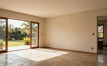 A spacious and airy living room in a modern South American home with freshly painted soft sand walls. Natural sunlight streams through large windows, highlighting the smooth texture of the paint. Professional composition, warm and inviting atmosphere.