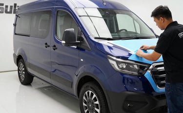 Professional technicians applying high-quality vinyl wrapping to a corporate vehicle in a clean, bright bay, Sul Americano industrial setting, sharp focus on the application process, vibrant textures, midnight blue and light sky blue accents.
