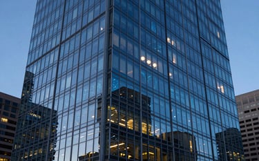 A sharp, high-end photograph of a modern glass high-rise building in downtown Denver during the blue hour. Soft electric blue light highlights the architectural lines, and subtle digital network patterns are reflected in the windows. North American / US setting.