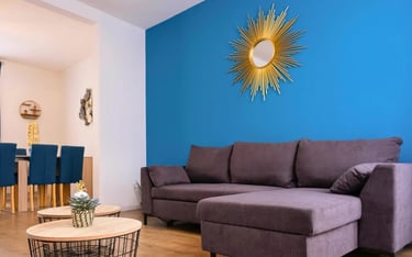 Salon lumineux avec canapé d’angle bleu, hébergement professionnel tout équipé