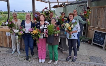 bloemschikken workshop trotse deelnemers met boeket